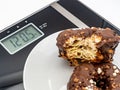 Closeup of a white plate with two delectable chocolate donuts on a weight scale Royalty Free Stock Photo