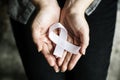 Closeup of white ribbon on hands palm bone cancer anti violence awareness