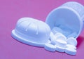 Closeup of white round pills pouring out of the medicine bottle on pink background Royalty Free Stock Photo