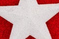 Closeup of a white star on red glitter textured paper Royalty Free Stock Photo