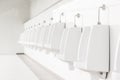 Closeup white tiles urinals in men`s bathroom, design of white ceramic urinals for men Royalty Free Stock Photo