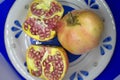 Closeup of whole and cut pomegranate on light blue plate Royalty Free Stock Photo