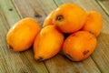 Closeup of whole ripe yellow loquat on wooden table. Vitamin fruits