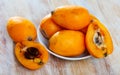 Closeup of whole ripe yellow loquat on wooden table. Vitamin fruits