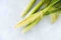 Closeup of Whole Unpeeled and Peeled Baby Corn with Leaves