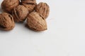 Closeup of whole walnuts under the lights on a white surface