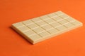 Closeup of a whole white chocolate bar isolated on an orange background Royalty Free Stock Photo