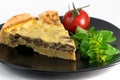 Closeup wide studio shot of a slice of yellow French salty cake, or quiche, with mushrooms on a black design plate, isolated on Royalty Free Stock Photo