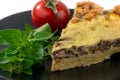 Closeup wide studio shot of a slice of yellow French salty cake, or quiche, with mushrooms on a black design plate, isolated on Royalty Free Stock Photo
