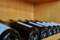 Closeup of wine bottles in a wooden shelf at a winery in Mendoza, Argentina Royalty Free Stock Photo