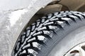 Closeup winter wheel with iron spikes for mud and snow terrain Royalty Free Stock Photo