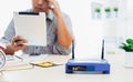 closeup of a wireless router and a man using smartphone on living room at home ofiice