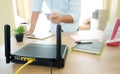 closeup of a wireless router and a man using smartphone on living room at home ofiice Royalty Free Stock Photo