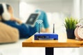 Closeup of a wireless router and a man using smartphone on living room at home ofiice Royalty Free Stock Photo