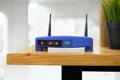 Closeup of a wireless router and a man using smartphone on living room at home ofiice Royalty Free Stock Photo