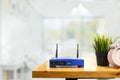 Closeup of a wireless router and a man using smartphone on living room at home ofiice Royalty Free Stock Photo