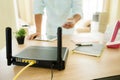 Closeup of a wireless router and a man using smartphone on living room at home ofiice Royalty Free Stock Photo