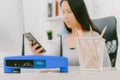 Closeup of a wireless router and a woman using smartphone on living room at home ofiice Royalty Free Stock Photo