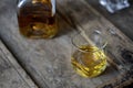 Closeup of a wisky glass and bottle on a rustic shabby wooden table from a high angle