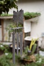 Closeup of a wolf metal hanging wind chime in a garden