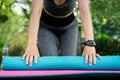 woman arm wearing smart watch folding yoga mat outdoor in green park