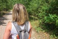 Closeup of woman with backpack on trailway in fir and pine trees forest. Concept of active lifestyle, hiking and tourism