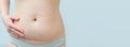 Closeup of woman belly with a scar from a cesarean section on blue background Royalty Free Stock Photo