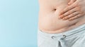 Closeup of woman belly with a scar from a cesarean section on blue background Royalty Free Stock Photo