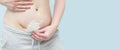 Closeup of woman belly with a scar from a cesarean section with a medical bandage on blue background Royalty Free Stock Photo