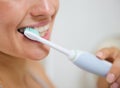 Closeup on woman brushing teeth