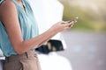 Closeup woman calling roadside assistance. Hands of a young woman dialling for help after a vehicle breakdown. Having