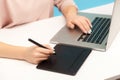 Closeup of woman designer hands working on graphic tablet and typing keyboard laptop, drawing sketch using stylus Royalty Free Stock Photo