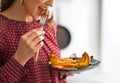 Closeup on woman eating baked pumpkin in kitchen