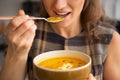 Closeup on woman eating pumpkin soup in kitchen Royalty Free Stock Photo