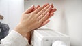 Closeup of woman feeling col warming her hands at wall heater