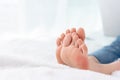 Closeup woman feet skin wearing jeans on white bed. Healthcare and health medical concept Royalty Free Stock Photo