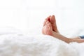 Closeup woman feet skin wearing jeans on white bed. Healthcare and health medical concept