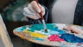 Closeup woman female hand artist painter paints draws creating new art work on canvas in workshop lesson of painting Royalty Free Stock Photo