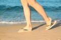 Closeup of woman with flip flops on sand. Beach accessories Royalty Free Stock Photo