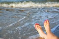Closeup of woman with flip flops on near sea, space for text. Beach accessories Royalty Free Stock Photo