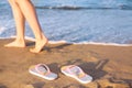 Closeup of woman and flip flops on sand near , space for text. Beach accessories Royalty Free Stock Photo