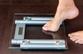 Closeup of woman foot uploading to bathroom scale Royalty Free Stock Photo