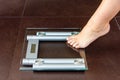 Closeup of woman foot uploading to bathroom scale Royalty Free Stock Photo