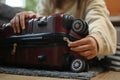 Closeup woman getting ready to travel vacation, packing suitcase for trip on floor in living room Royalty Free Stock Photo