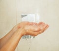 Closeup on woman hand catching water drops in shower