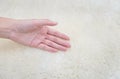 Closeup woman hand on white fabric carpet made from wool textured background