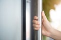 Closeup woman hand holding the door bar to open the door with glass reflection background Royalty Free Stock Photo