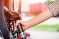 Closeup of woman hand holding a fuel pump at a station. Royalty Free Stock Photo