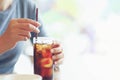 closeup woman Hand holding glass of cola drink in restaurant background, Woman hand glass soft drinks with ice