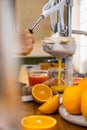 Closeup woman hand holding glass under flow of detox healthy orange juice use citrus press Royalty Free Stock Photo